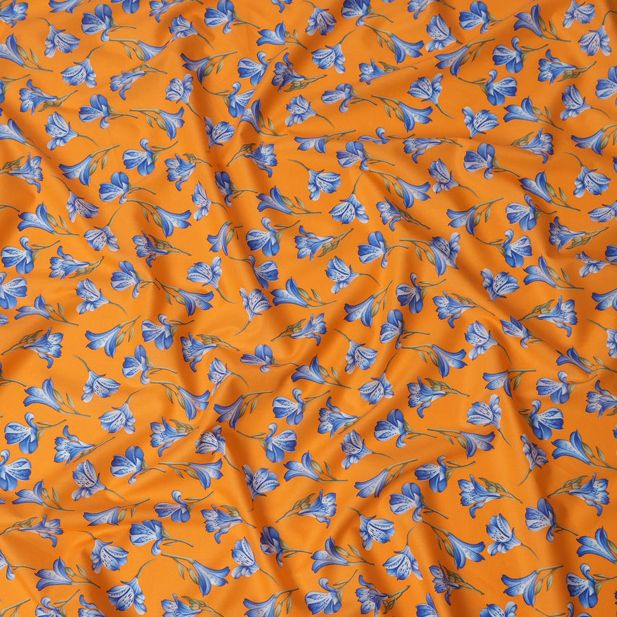 قماش قطني برتقالي اللون مع طبعة زهور زرقاء بالكامل ولمسات من أوراق الشجر الخضراء الزيتونية، خفيف الوزن وناعم الملمس، عرض 110 سم، صنع في الهند - D22539
