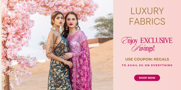 Two women in elegant dresses standing under a cherry blossom tree with % discount on Regal Fabrics - luxury fabrics and exclusive savings.