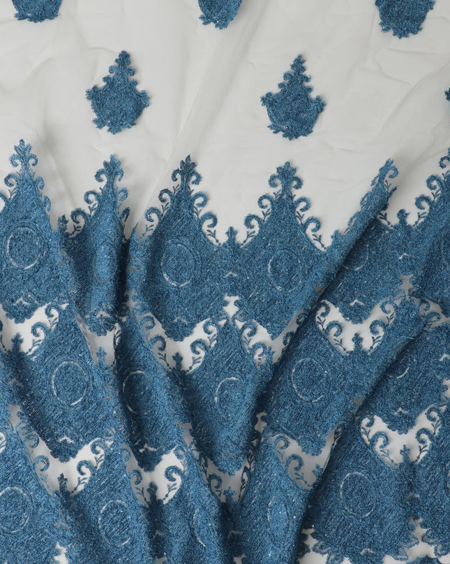 Beige nylon tulle fabric with dark Turkish blue embroidery in fancy design