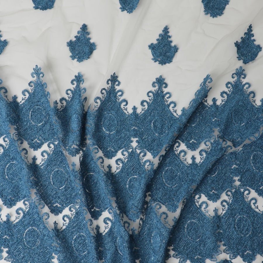 Beige nylon tulle fabric with dark Turkish blue embroidery in fancy design