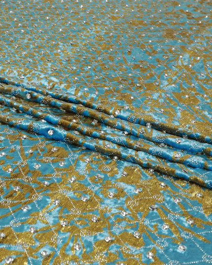 cerulean blue Rayon velvet fabric with metallic gold fringe embroidery and white stones in abstract design