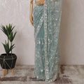 Light teal Premium net saree with same tone embroidery having light pink sequin work and gold bead work in floral design-D15586
