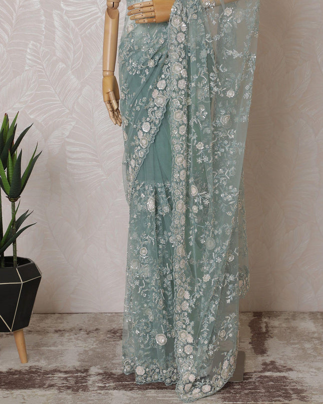 Light teal Premium net saree with same tone embroidery having light pink sequin work and gold bead work in floral design-D15586