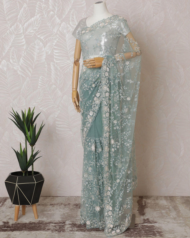 Light teal Premium net saree with same tone embroidery having light pink sequin work and gold bead work in floral design-D15586