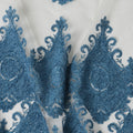 Beige nylon tulle fabric with dark Turkish blue embroidery in fancy design