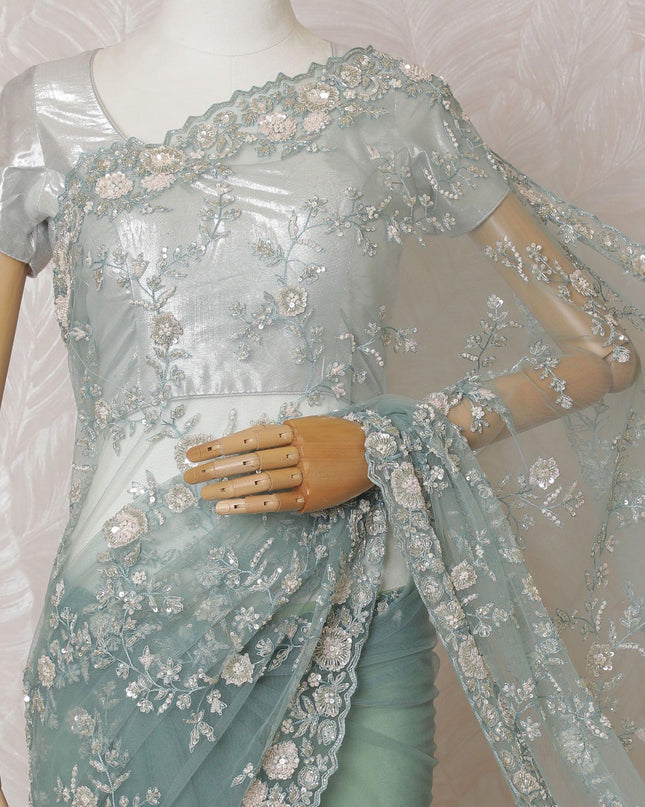 Light teal Premium net saree with same tone embroidery having light pink sequin work and gold bead work in floral design-D15586