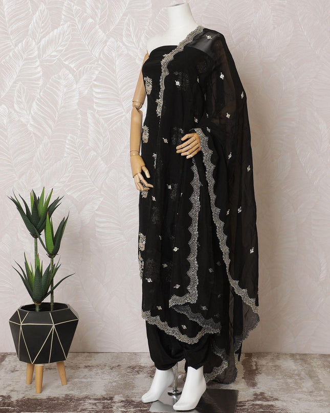 Black silk crepe kameez with gold embroidery, sequins and bead work in floral design. Black plain salwar with same tone flat chiffon dupatta having gold embroidery and mirror work-D15529